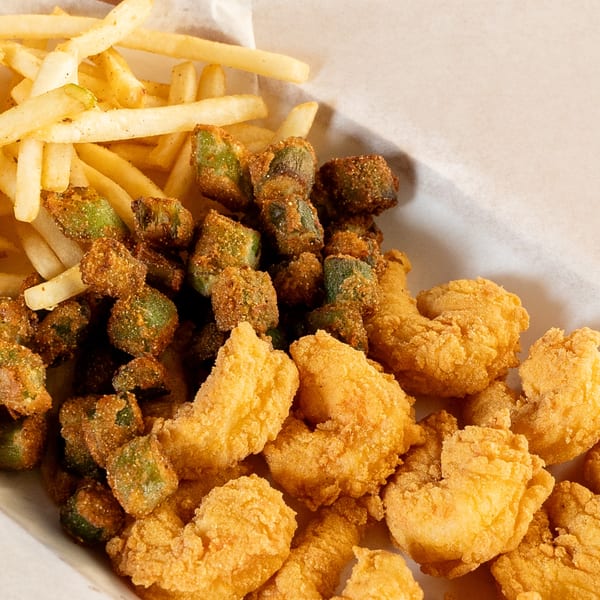 King Cajun Crawfish fried shrimp, okra, and french fries in a white paper tray.